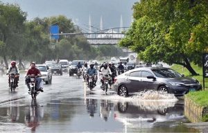 Vehicles navigate through stagnant rainwater following heavy rainfall in the Federal Capital