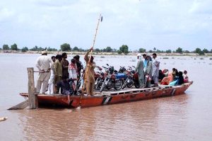 People load motorcycles and other equipment onto boats to cross the Sutlej River in the Nawahi area. AP