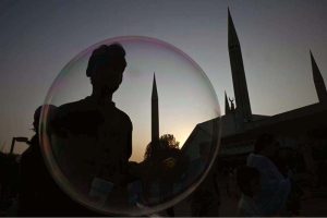A vendor makes bubbles to attract the children visiting the famous Faisal Masjid during evening time in Federal Capital