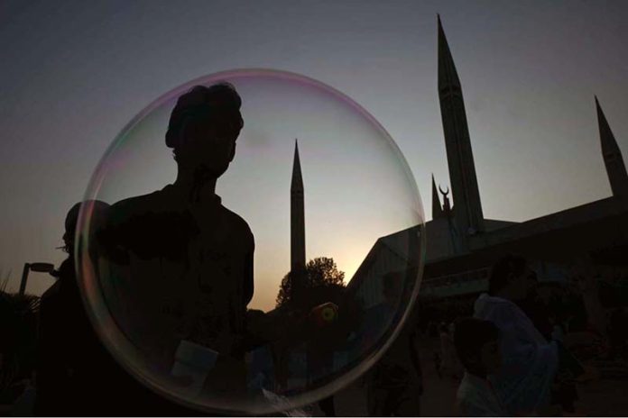 A vendor makes bubbles to attract the children visiting the famous Faisal Masjid during evening time in Federal Capital