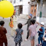 A street vendor in the Korangi area attracts children by selling balloons