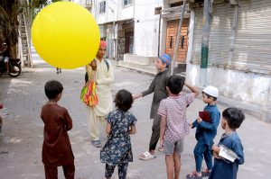 A street vendor in the Korangi area attracts children by selling balloons
