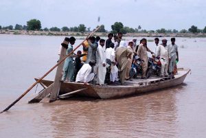 People load motorcycles and other equipment onto boats to cross the Sutlej River in the Nawahi area. AP