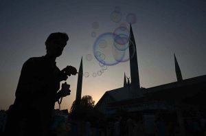 A vendor makes bubbles to attract the children visiting the famous Faisal Masjid during evening time in Federal Capital