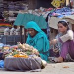 Women vendors waiting for customers to sell colorful bangles at their roadside stall in a local market
