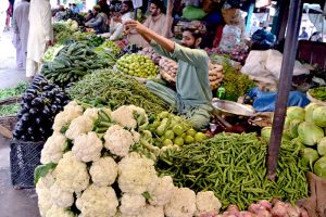 A vendor displays vegetables to attract customers at a local vegetable market