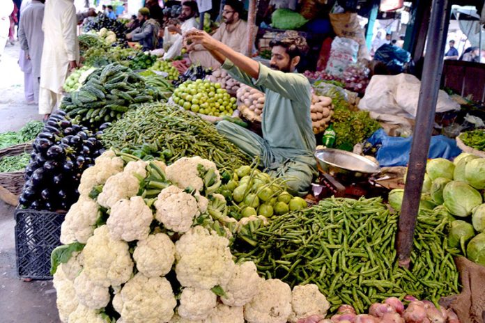 A vendor displays vegetables to attract customers at a local vegetable market