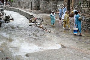 Children enjoy bathing, jumping, and splashing in flooded streets after a torrential downpour in Saidpur Village of the Federal Capital