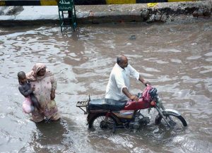 Women wade through rainwater on Jhumra Road near Nishatabad Bridge causing public inconvenience after a monsoon downpour