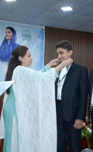 Divisional Commissioner Madam Maryam Khan presses a button on a laptop to announce and release the results of the First Annual Matriculation Examinations during a formal result announcement ceremony at Divisional Model College, Faisalabad
