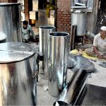 Workers busy in preparing huge iron containers for the storage of wheat to the customers at their workplace