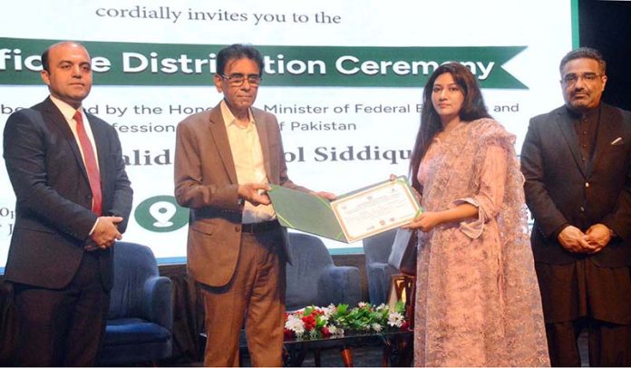 Federal Minister for Education and Professional Training Dr. Khalid Maqbool Siddiqui giving away certificate during a Certificate Distribution Ceremony organized by NAVTTC at Arts Council of Pakistan