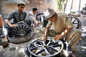 Workers busy in repairing vehicles rim at their workplace at Shoba Bazar.