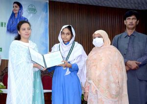 Divisional Commissioner Madam Maryam Khan presses a button on a laptop to announce and release the results of the First Annual Matriculation Examinations during a formal result announcement ceremony at Divisional Model College, Faisalabad