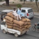 A heavily loaded van transports vegetables as sellers carry fresh produce from the new Sabzi Mandi