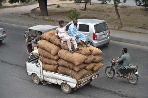 A heavily loaded van transports vegetables as sellers carry fresh produce from the new Sabzi Mandi
