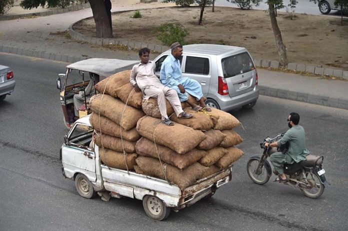 A heavily loaded van transports vegetables as sellers carry fresh produce from the new Sabzi Mandi