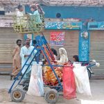 Children enjoy riding a mini Sky Wheel on the side of the road in a neighborhood of Bahawalpur city