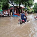 A motorcyclist passes through a flooded area after torrential monsoon rains submerged Jhang Road, Committee Chowk, Furniture Market, and Girls College Road, causing inconvenience to citizens