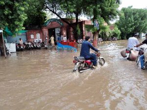 A motorcyclist passes through a flooded area after torrential monsoon rains submerged Jhang Road, Committee Chowk, Furniture Market, and Girls College Road, causing inconvenience to citizens