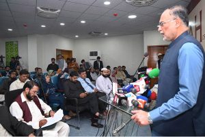 Program host Qamarul Haq presents a shield to Federal Minister for Planning, Development and Special Initiatives, Ahsan Iqbal, during the Seerah Workshop at Seerah Center