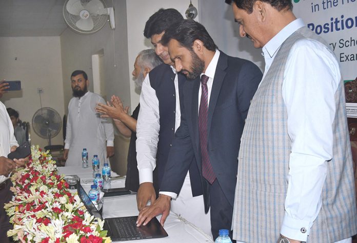 Commissioner Amir Karim Khan, along with Deputy Commissioner Waseem Hamid Sindhu, presses a button to officially launch the 10th class annual results online