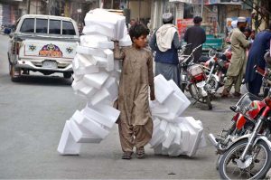 A young boy learns to prepare traditional ice cream (Kulfi) boxes under the guidance of his master amid rising summer demand