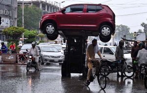 A traffic warden removing a wrong side parked car with help of fork lifter on 6th Road.