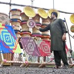 A vendor arranges beautiful handicrafts items made from cane and palm leaves at a roadside near the toll plaza at 17 Meel in the federal capital