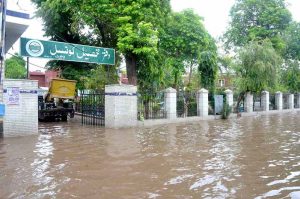 A motorcyclist passes through a flooded area after torrential monsoon rains submerged Jhang Road, Committee Chowk, Furniture Market, and Girls College Road, causing inconvenience to citizens