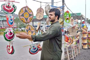 A vendor arranges beautiful handicrafts items made from cane and palm leaves at a roadside near the toll plaza at 17 Meel in the federal capital