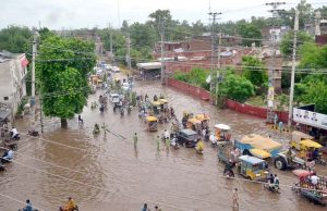 A motorcyclist passes through a flooded area after torrential monsoon rains submerged Jhang Road, Committee Chowk, Furniture Market, and Girls College Road, causing inconvenience to citizens