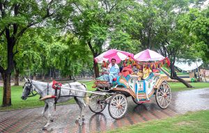 Visitors enjoy camel ride at Rawal Lake View Park during a pleasant weather after downpour that experienced throughout the day in the federal capital.