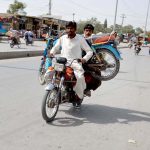 A motorcyclist transports a out of order motorcycle to a nearby mechanic for repair on Joint Road in Quetta