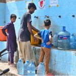 Youngsters fill their bottles with clean drinking water from a filtration plant in Phuleli area to stay hydrated amid the sweltering summer heat