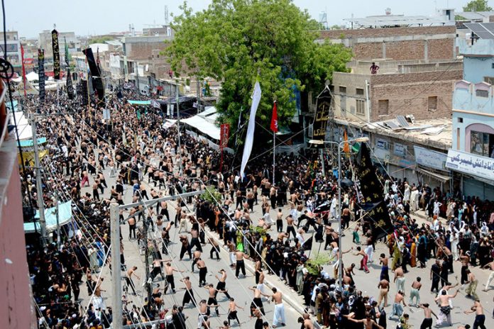 A large number of people beating themselves with chained Knives in a mourning procession of 9th Muharam ul Harm to commemorate the martyrdom of Hazrat Imam Hussain (RA), the grandson of Prophet Muhammad (PBUH) at Mumtazabad