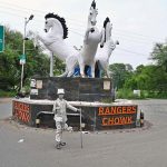 A girl poses as a silver statue at Rangers Chowk, hoping to catch the attention of passersby and earn a livelihood for her family