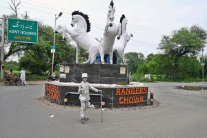 A girl poses as a silver statue at Rangers Chowk, hoping to catch the attention of passersby and earn a livelihood for her family
