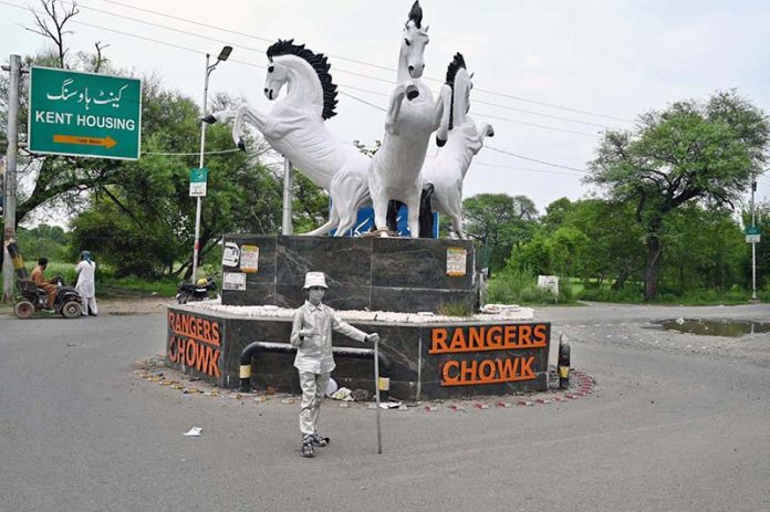 A girl poses as a silver statue at Rangers Chowk, hoping to catch the attention of passersby and earn a livelihood for her family