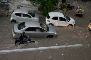 Vehicles pass through stagnant rainwater accumulated after heavy rainfall in the city.