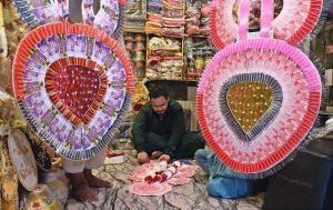 A daily-wage laborer pulls an overloaded cart of goods for transport and delivery to the market in Raja Bazaar, one of the busiest areas in the twin cities