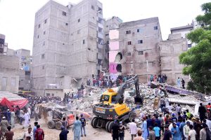 Heavy machinery is deployed for rescue operations after a residential building collapsed in Baghdadi, Lyari. Several people are feared dead and injured