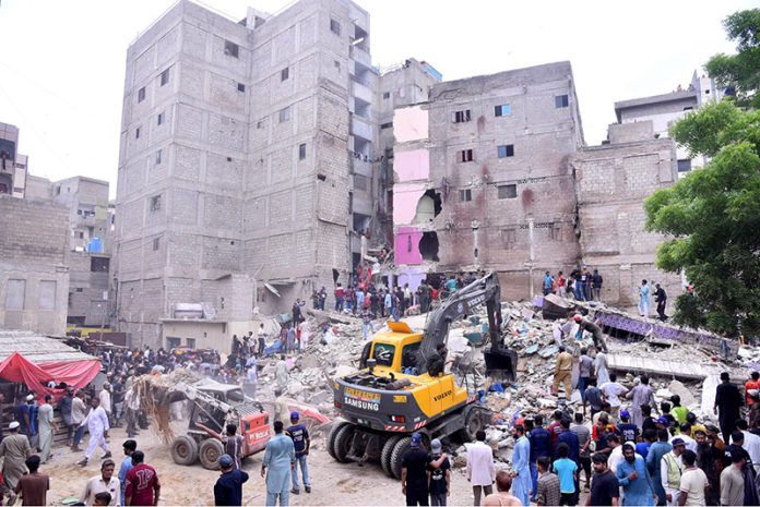 Heavy machinery is deployed for rescue operations after a residential building collapsed in Baghdadi, Lyari. Several people are feared dead and injured