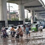 Vehicles passing through accumulated water on Multan Road after rain in the provincial capital