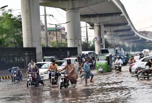Vehicles passing through accumulated water on Multan Road after rain in the provincial capital