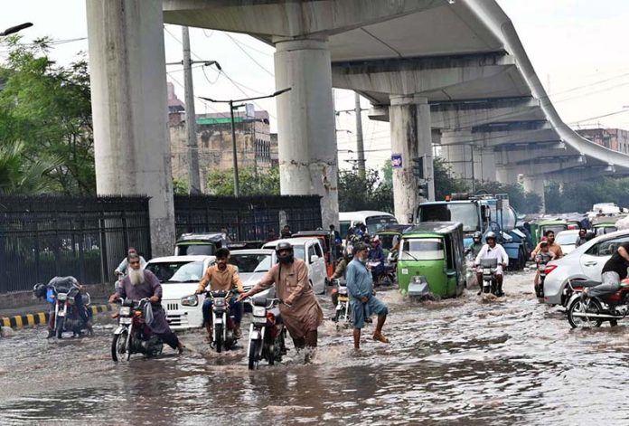 Vehicles passing through accumulated water on Multan Road after rain in the provincial capital