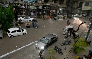 Vehicles pass through stagnant rainwater accumulated after heavy rainfall in the city.
