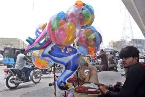 A vendor selling balloons at a roadside.