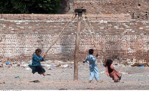 PESHAWAR: July 18 – Street children enjoy a swing ride by the roadside near Ring Road, making the most of a simple moment of joy.