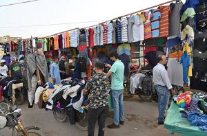People purchasing second hand Shirts trouser and other clothes at vendors roadside setup in the City.